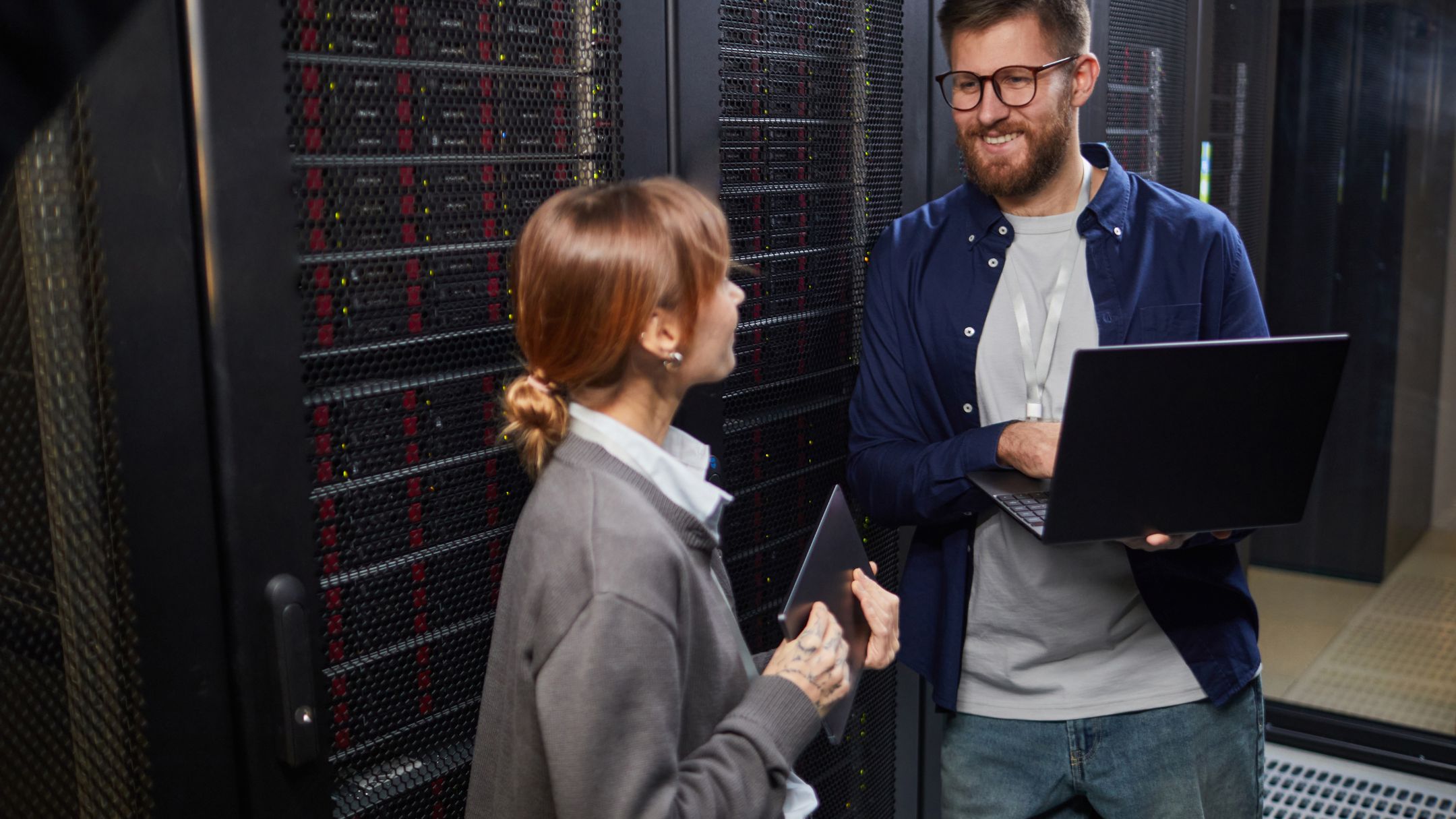 Colegas de una fintech colaborando junto a un centro de datos